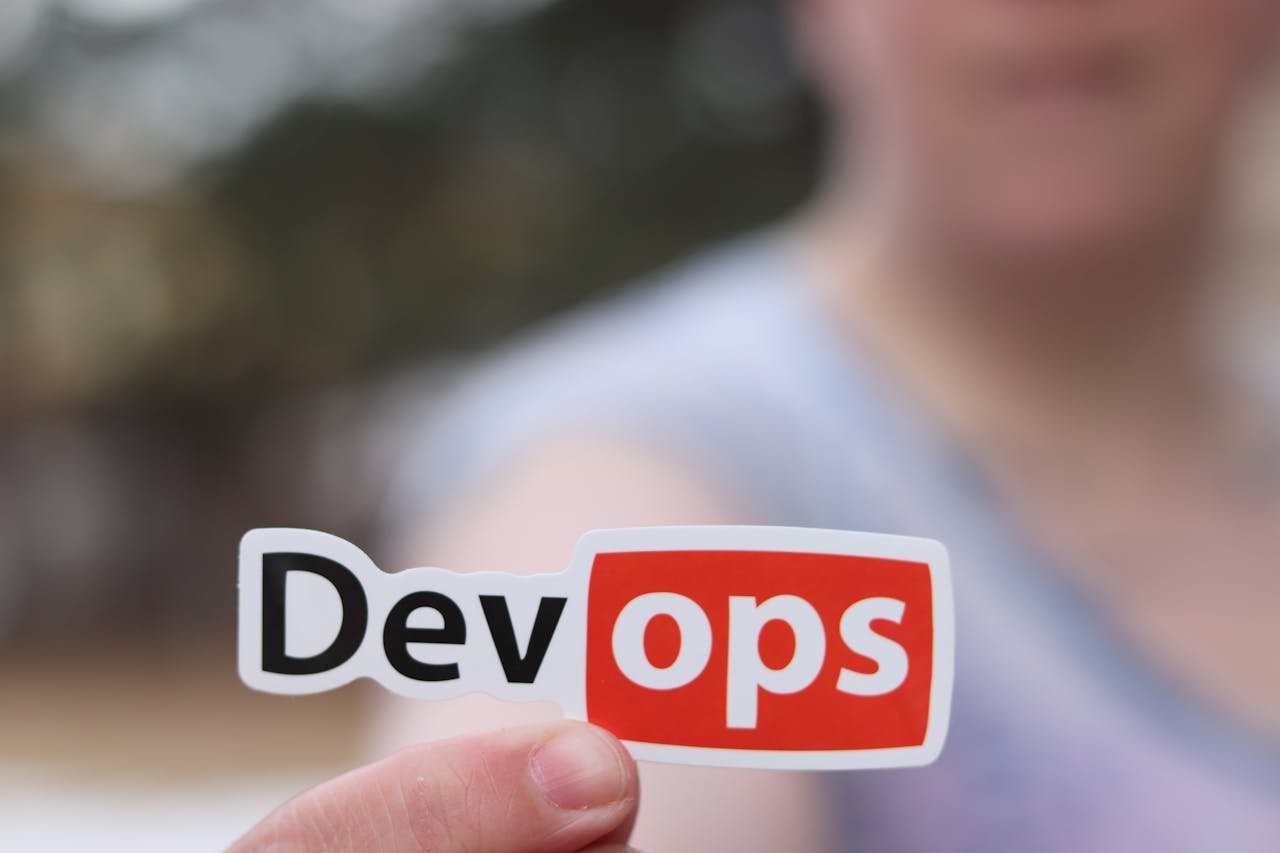 services-03 A close-up image featuring a DevOps sticker held by a person outdoors.