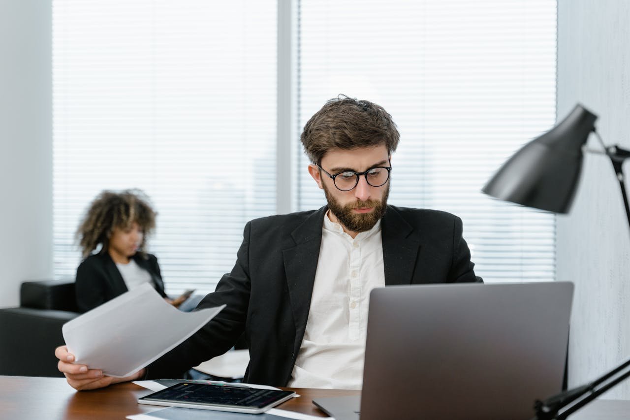 journey Two business professionals analyzing data on a laptop in a modern office setting, focusing on strategy.