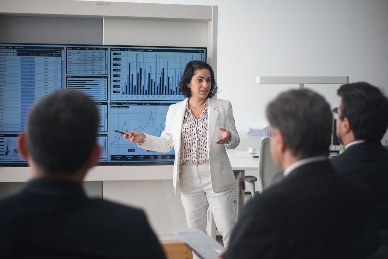 services-04 Professional woman presenting stock market data in a modern office setting.